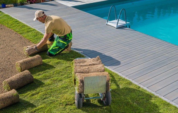 Concrete crew installing and finishing slip-resistant pool deck surface around residential swimming pool in Frisco, TX