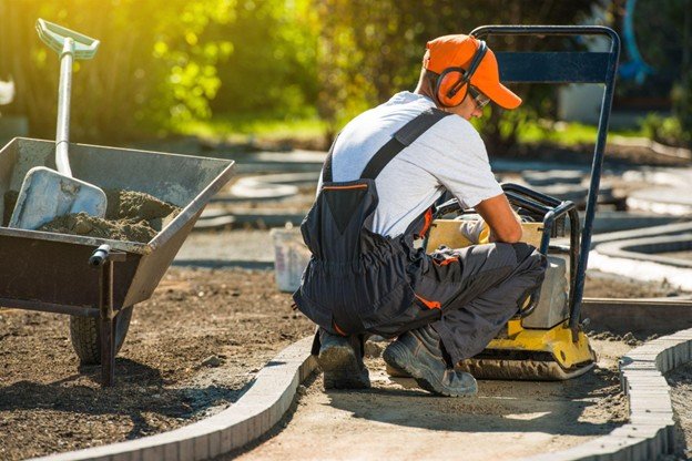Concrete paving crew leveling and finishing a reinforced concrete roadway surface