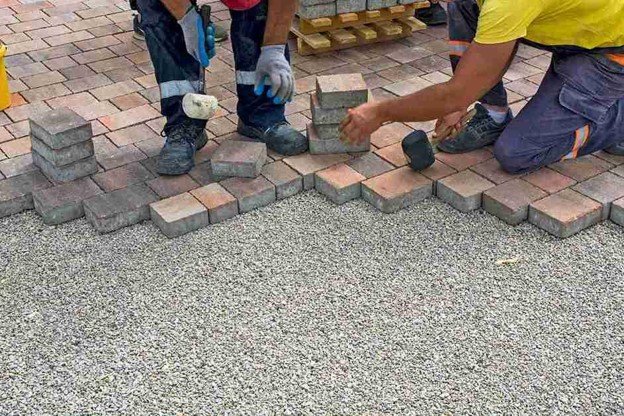 Concrete contractors installing paver driveway edge with gravel base preparation in Strongsville, OH