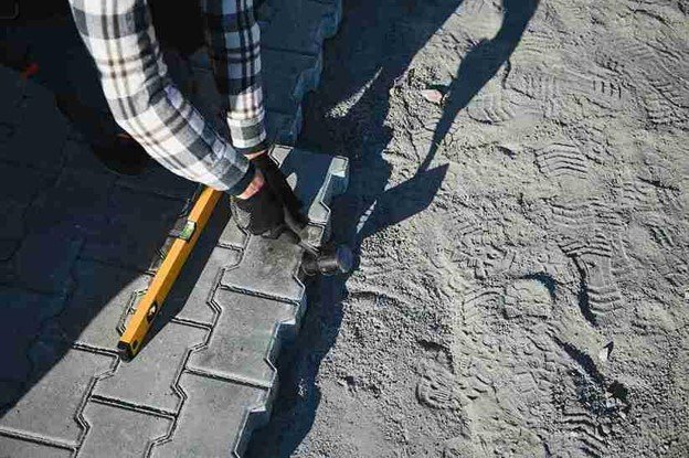 Stamped concrete installation with worker shaping and finishing textured surface in Strongsville, OH